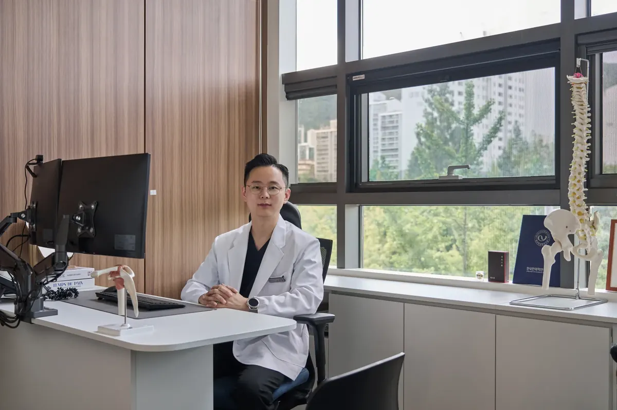 군포 산본 몸앤장한의원 진료실 책상에 앉아 있는 원장