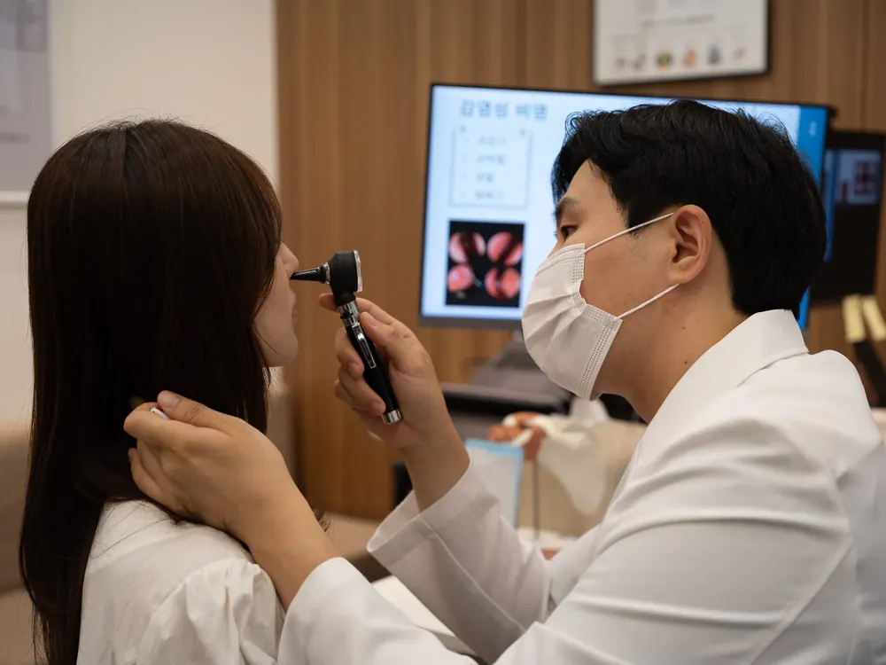 군포 산본 몸앤장한의원 원장이 환자의 귀 상태를 살피며 진료하는 모습